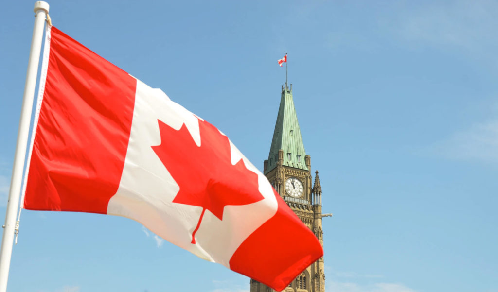 カナダの国旗とオンタリオ州国会議事堂（オタワ）の時計台の画像
