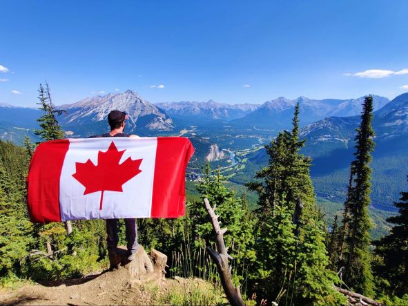 カナダの国旗を持つ男性の後ろ姿