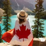 カナダの国旗を羽織る女性の後ろ姿