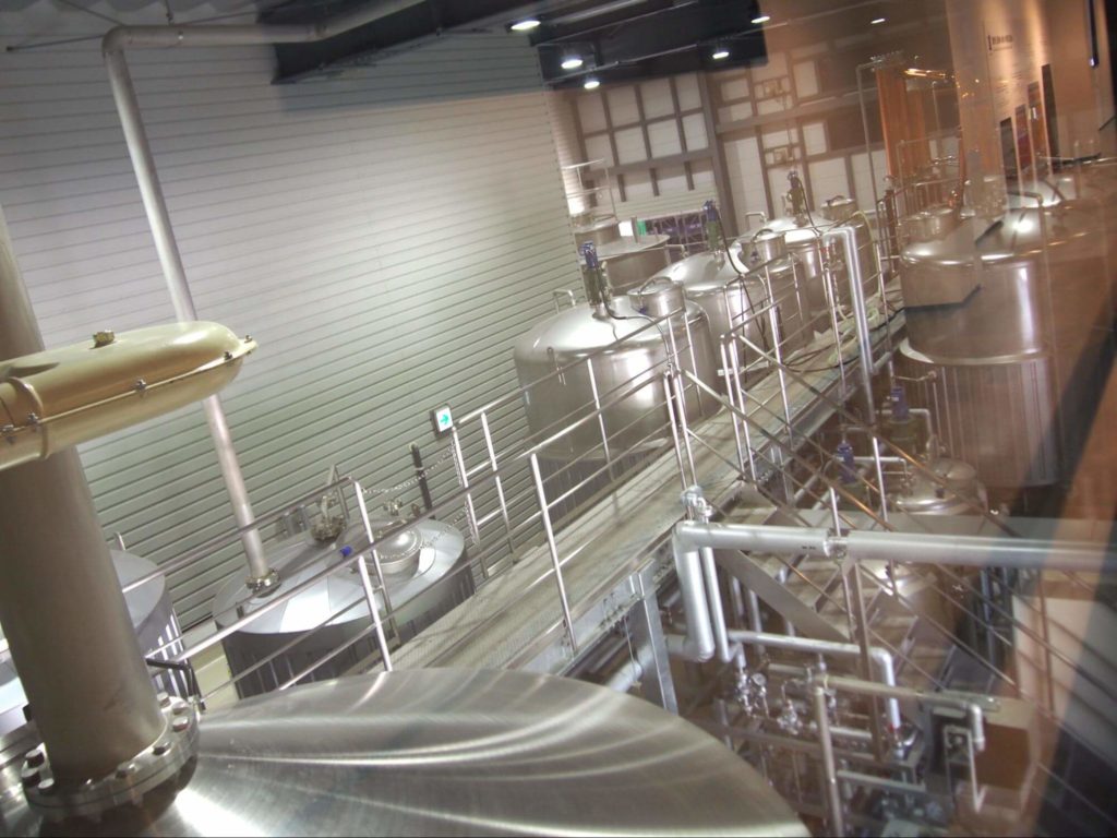 大きな糖化槽(マッシュタン)と、発酵槽(ウォッシュバック)5基の写真