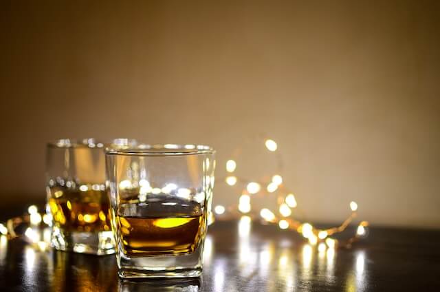 ライトアップされたテーブルの上に並ぶ2つのウイスキーグラス